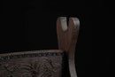 Supporto per katana in legno decorato con finitura scura, elaborati intagli floreali ed eleganti linee curve su sfondo nero. Supporto Katana Keshiki.