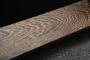 Base in legno con venature elaborate in calde tonalità marroni, primo piano angolato, parte di un supporto per katana. Supporto Katana Heiwa.