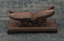 Supporto per katana in legno scuro riccamente intagliato con motivo ad aquila su una superficie testurizzata, vista frontale. Supporto Katana Washi all'estremità.