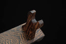 Primo piano di un supporto per katana in legno dalle venature elaborate con sostegni curvi, su sfondo nero. Supporto Katana Heiwa.