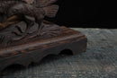 Primo piano di un supporto per katana in legno scuro con intaglio elaborato di uccello, che mette in risalto texture e lavorazione dettagliata. Supporto Katana Washi all'estremità.