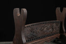 Supporto per katana in legno scuro con elaborati intagli floreali e curve eleganti, in risalto su sfondo nero. Supporto Katana Keshiki.