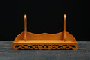 Supporto per katana in legno decorato con sostegni curvi e base dal design elaborato su sfondo scuro, Supporto Katana Taiyou.